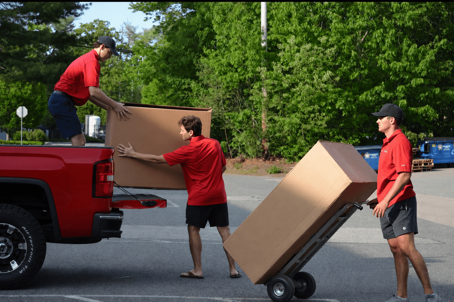 The Big Red Moving crew loading a large item onto their red truck in Hingham, MA